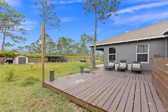 wooden terrace featuring a yard and a shed