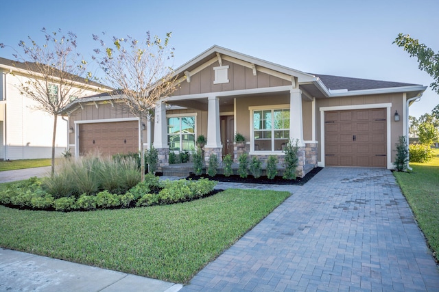 craftsman house featuring a front yard, a porch, and a garage