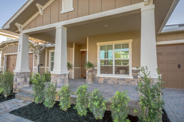 view of exterior entry with a porch and a garage