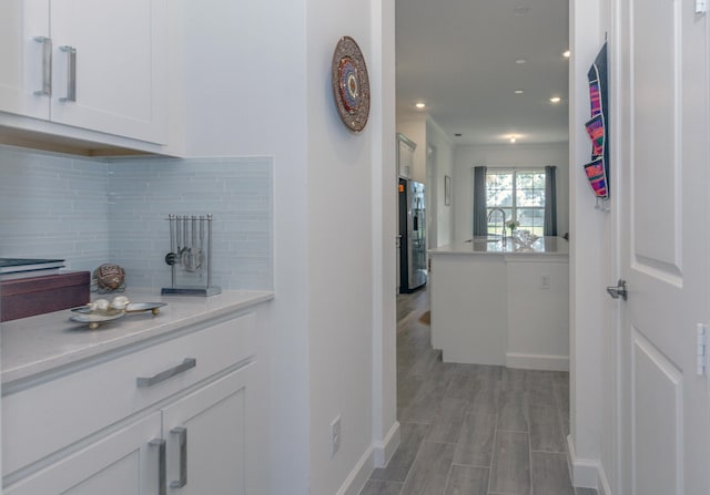 hall with light wood-type flooring and sink