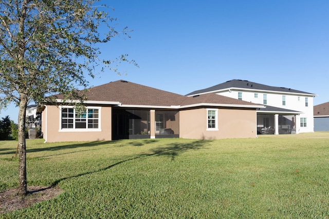 rear view of house with a sunroom and a lawn