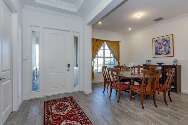 dining space featuring hardwood / wood-style floors and crown molding