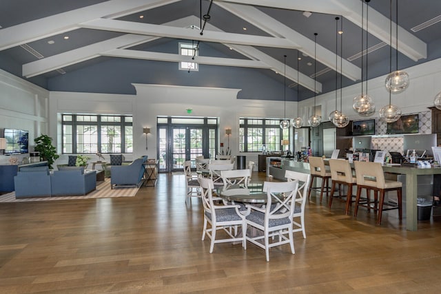 dining space featuring plenty of natural light, high vaulted ceiling, wood-type flooring, and french doors