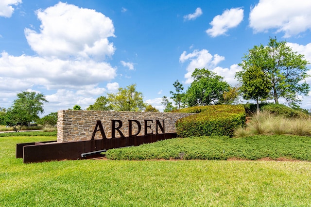 community / neighborhood sign featuring a yard