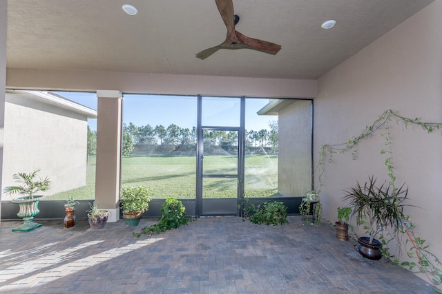 unfurnished sunroom with ceiling fan and a wealth of natural light