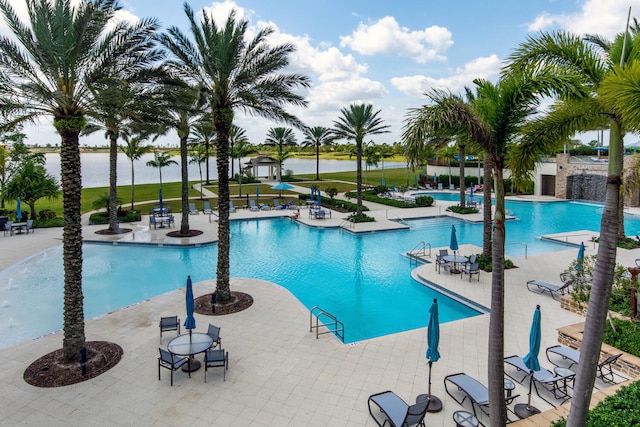 view of swimming pool featuring a patio area and a water view