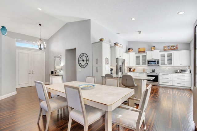 dining area featuring a notable chandelier, dark hardwood / wood-style flooring, and high vaulted ceiling