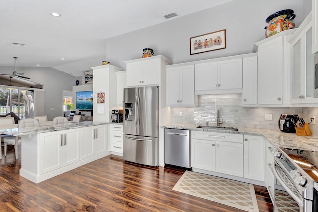 kitchen featuring white cabinets, appliances with stainless steel finishes, dark hardwood / wood-style flooring, and lofted ceiling