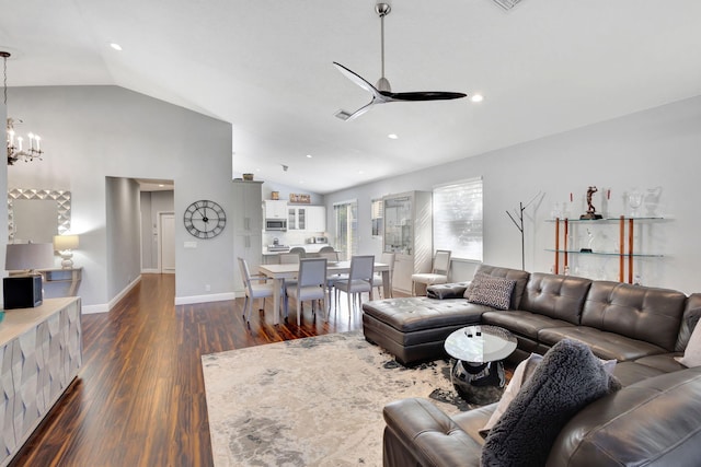 living room featuring ceiling fan with notable chandelier, dark hardwood / wood-style flooring, and vaulted ceiling