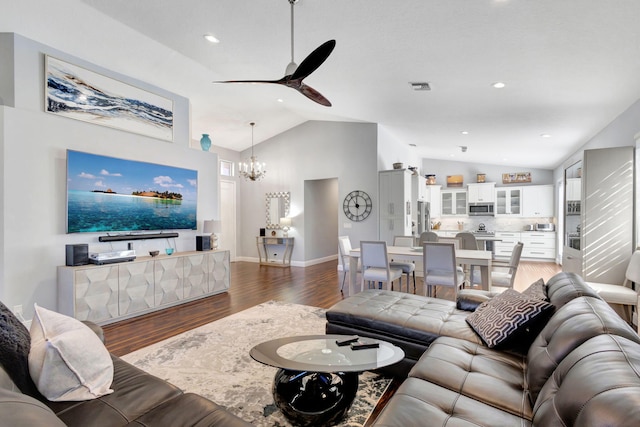 living room featuring dark hardwood / wood-style flooring, ceiling fan with notable chandelier, and lofted ceiling