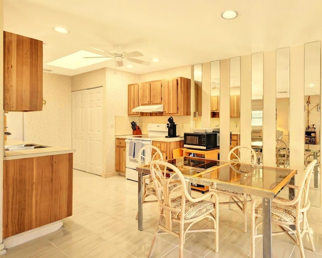 kitchen featuring electric range, ceiling fan, and sink