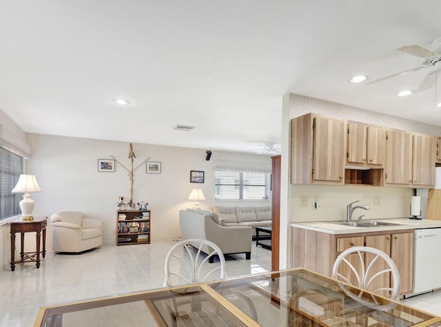 kitchen with dishwasher, light tile patterned floors, sink, and light brown cabinetry