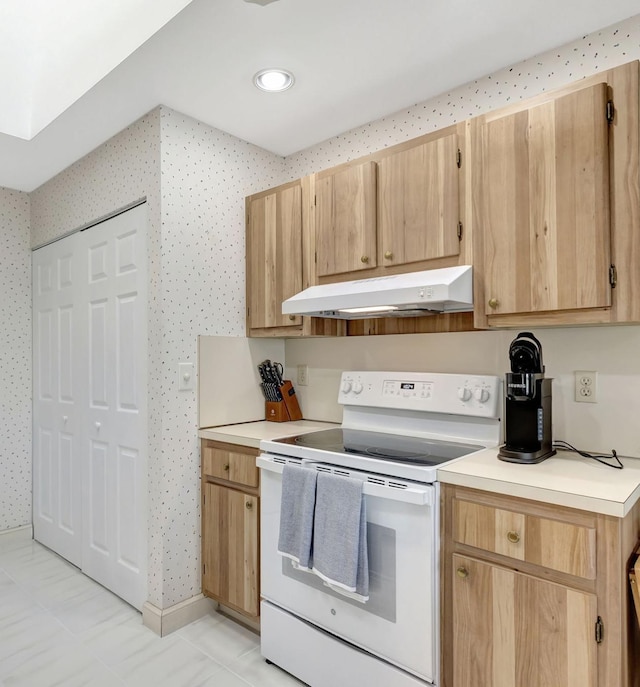 kitchen featuring electric stove, light brown cabinets, and light tile patterned flooring