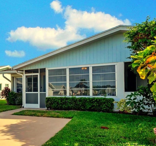 back of house featuring a yard and a sunroom