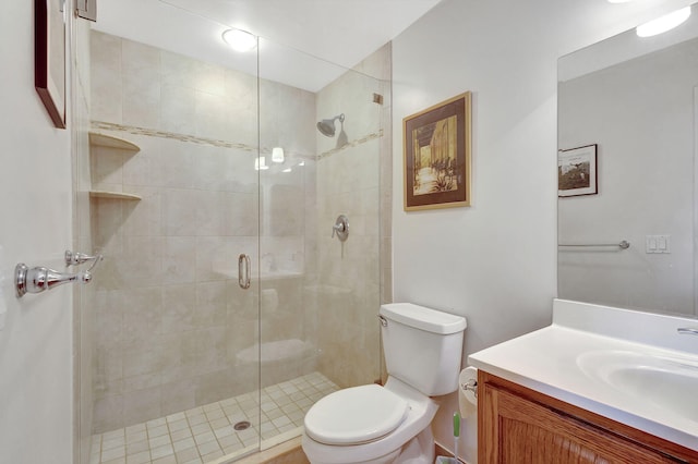 bathroom featuring vanity, a shower with shower door, and toilet