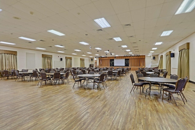 dining space featuring a paneled ceiling and light wood-type flooring