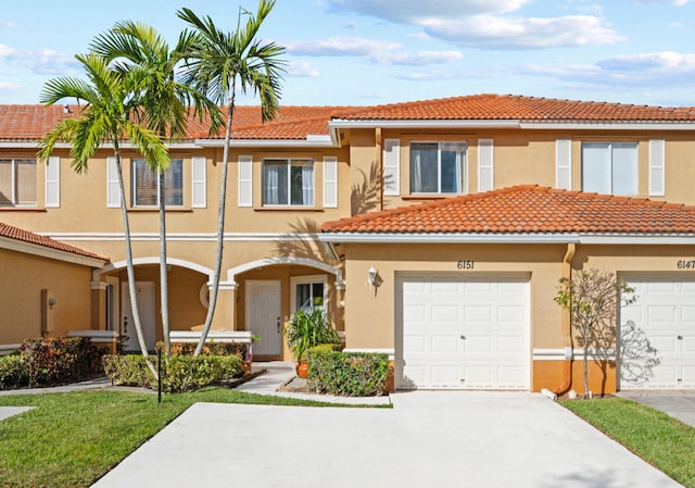 view of property with a tiled roof, a garage, concrete driveway, and stucco siding