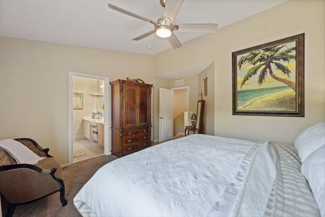 carpeted bedroom with ensuite bath and ceiling fan