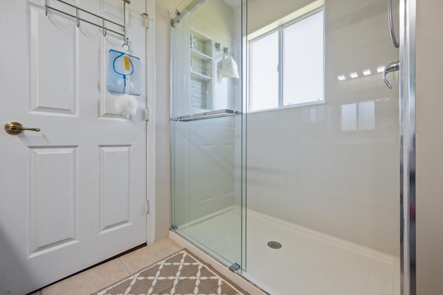 full bathroom featuring tile patterned floors and a shower stall