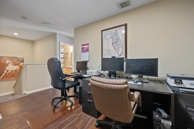 office space with dark wood-type flooring, baseboards, and visible vents