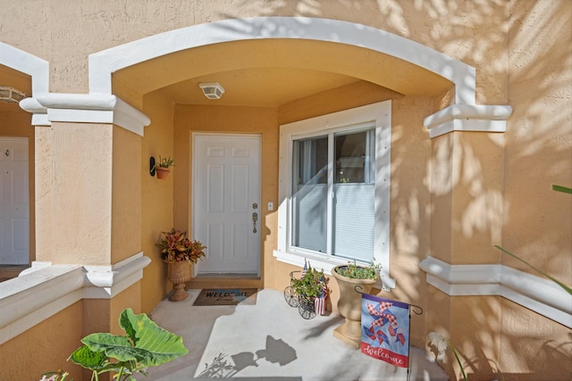 entrance to property featuring stucco siding