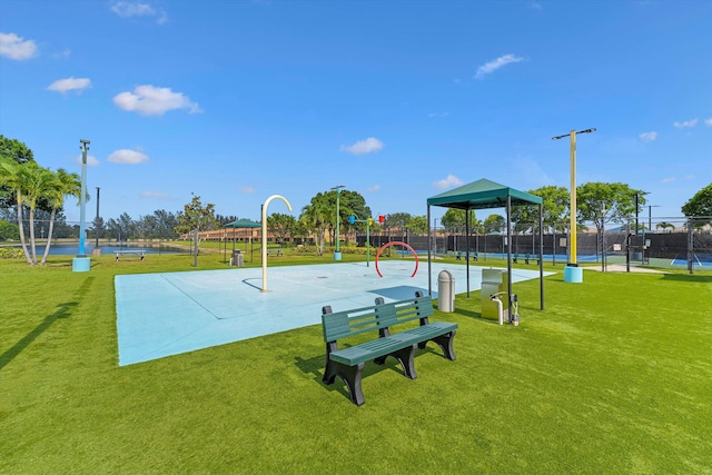view of home's community featuring community basketball court, a yard, fence, and playground community