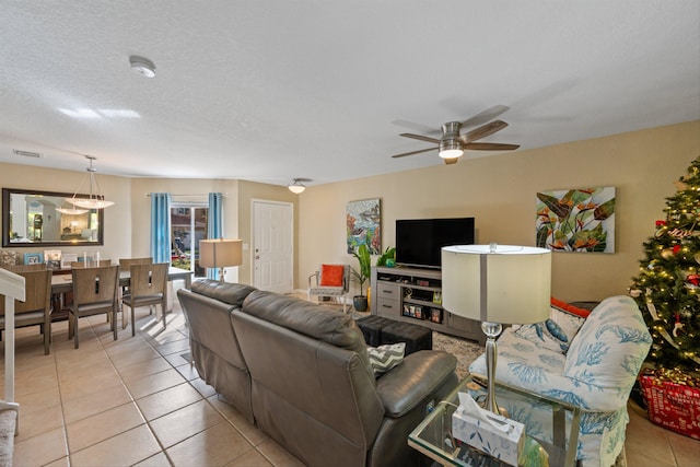 tiled living room featuring ceiling fan and a textured ceiling