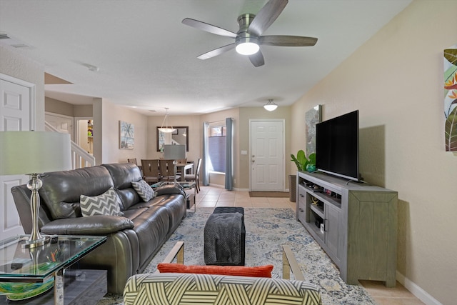 living area with light tile patterned flooring, visible vents, baseboards, and ceiling fan