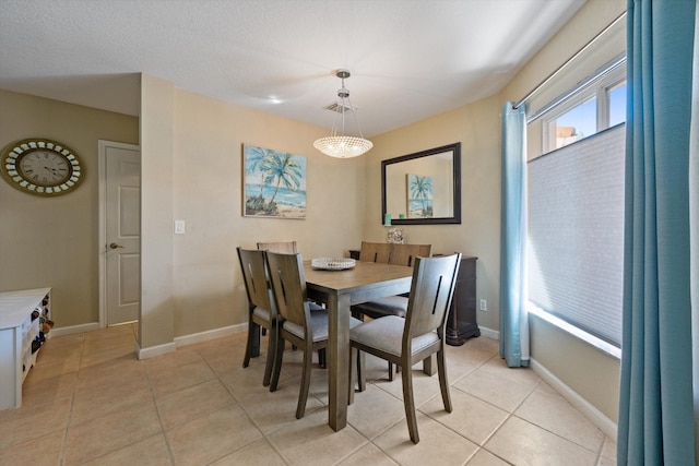 dining area featuring light tile patterned floors, visible vents, and baseboards