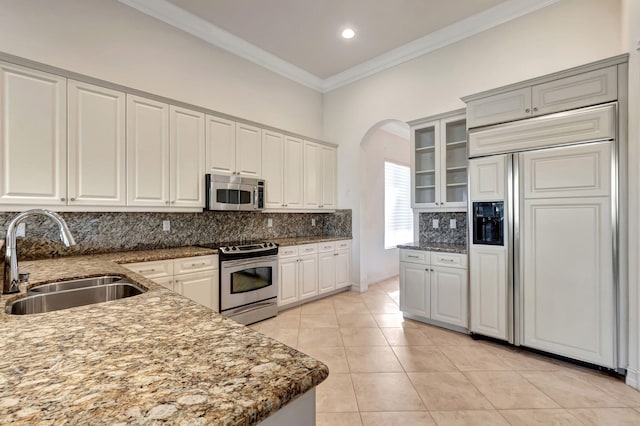 kitchen with sink, light tile patterned floors, backsplash, white cabinets, and appliances with stainless steel finishes