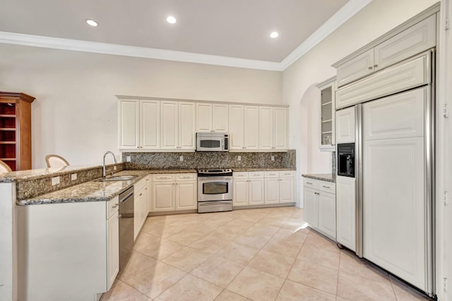 kitchen with kitchen peninsula, appliances with stainless steel finishes, white cabinetry, and sink