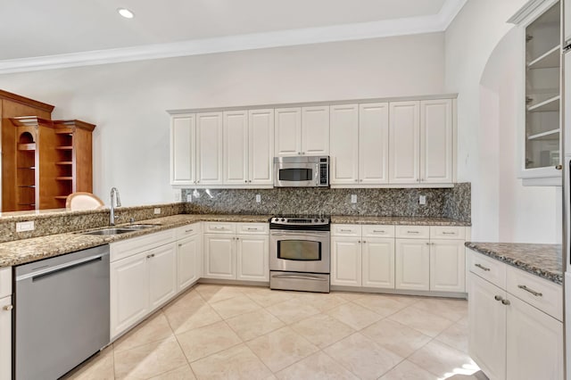 kitchen with appliances with stainless steel finishes, tasteful backsplash, white cabinetry, and sink