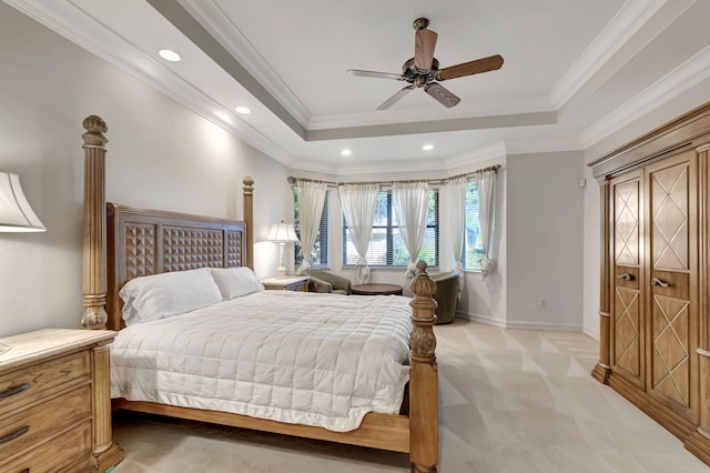 bedroom with a raised ceiling, ceiling fan, light carpet, and ornamental molding