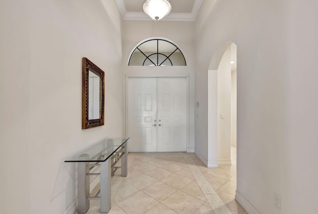 foyer featuring crown molding and a high ceiling