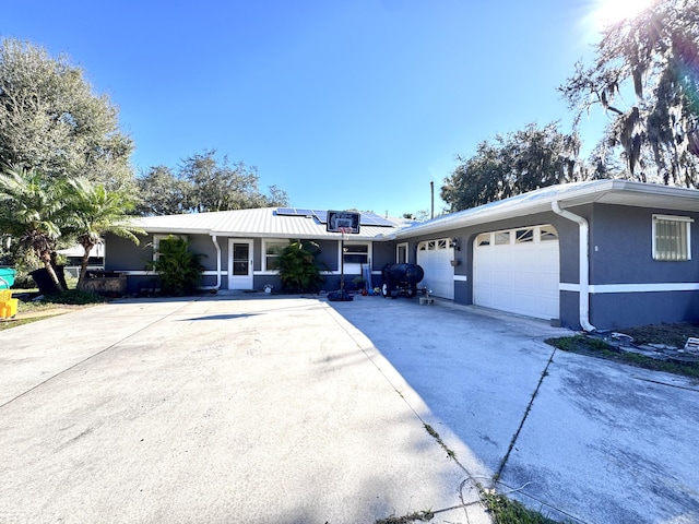 ranch-style house with solar panels and a garage