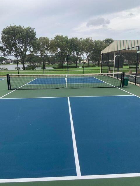 view of tennis court with basketball hoop