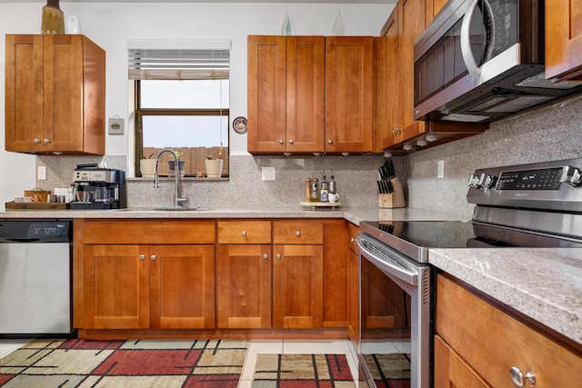 kitchen featuring stainless steel appliances, sink, decorative backsplash, and light tile patterned floors