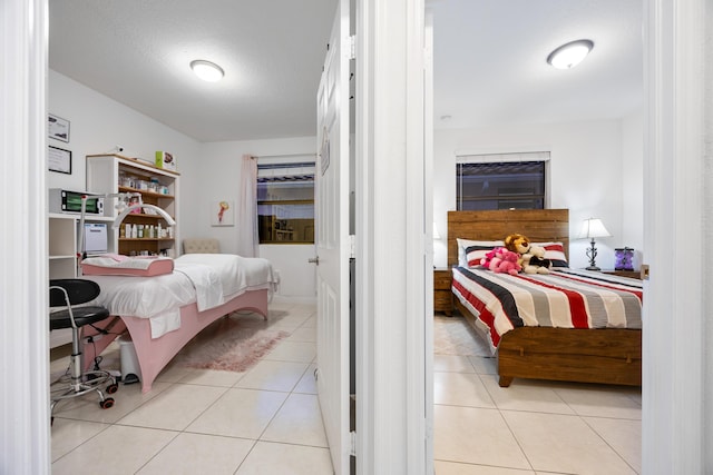 bedroom featuring light tile patterned floors and a textured ceiling