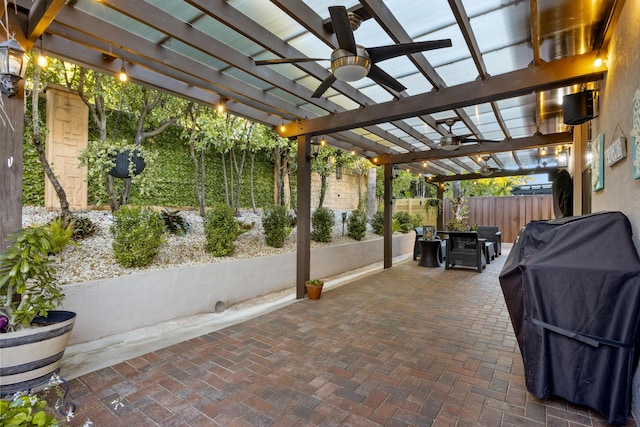 view of patio with area for grilling, ceiling fan, and a pergola