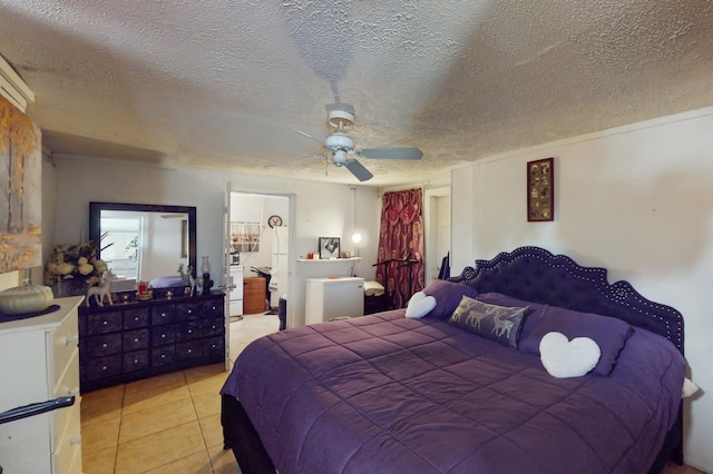 bedroom featuring ceiling fan, light tile patterned floors, and a textured ceiling