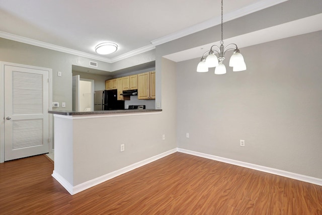 kitchen with pendant lighting, an inviting chandelier, black refrigerator, crown molding, and light wood-type flooring