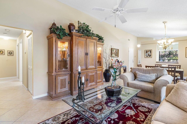 living room featuring ceiling fan with notable chandelier, light tile patterned floors, a textured ceiling, and vaulted ceiling