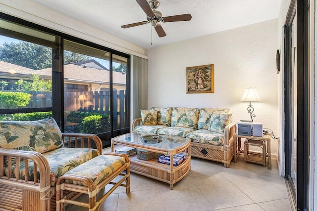 living room with a textured ceiling, ceiling fan, and light tile patterned flooring