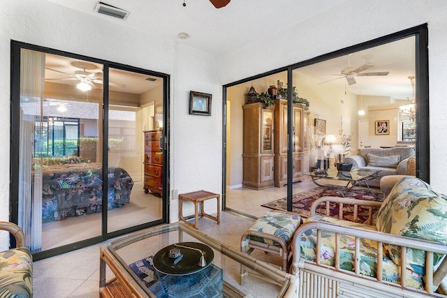 tiled living room with a wealth of natural light, a chandelier, and vaulted ceiling