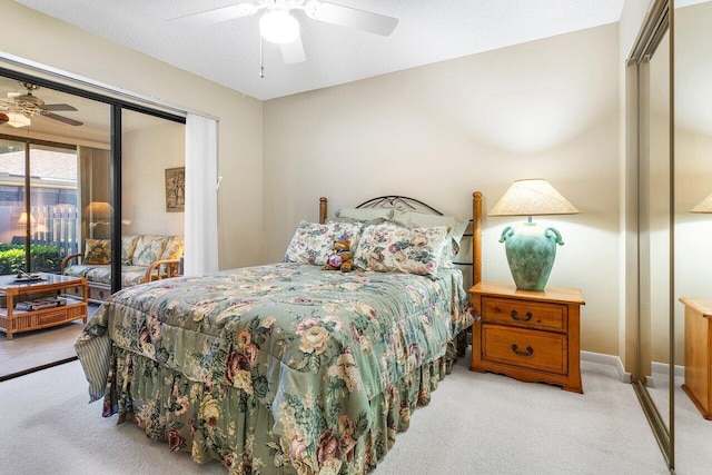 bedroom featuring ceiling fan, light colored carpet, a textured ceiling, and a closet