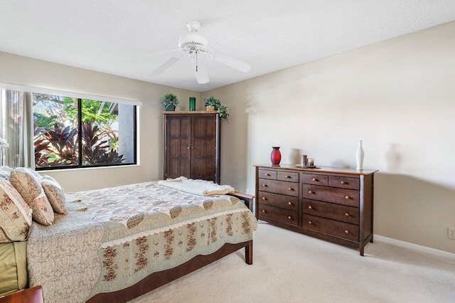 carpeted bedroom featuring a textured ceiling and ceiling fan