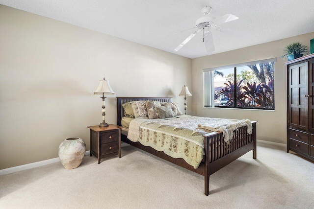 carpeted bedroom featuring ceiling fan and a textured ceiling