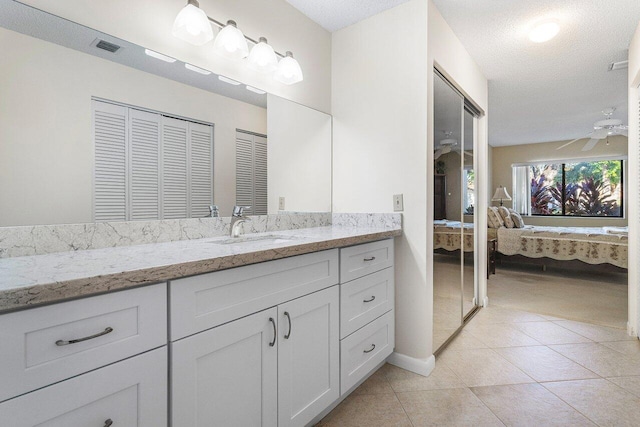 bathroom featuring vanity, a textured ceiling, ceiling fan, and tile patterned flooring