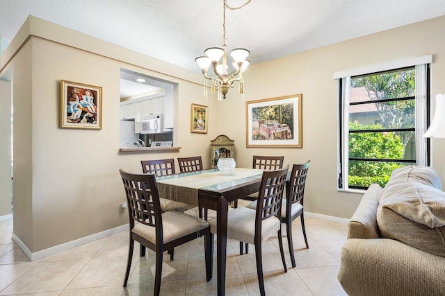 dining space with a wealth of natural light, light tile patterned flooring, a textured ceiling, and a notable chandelier