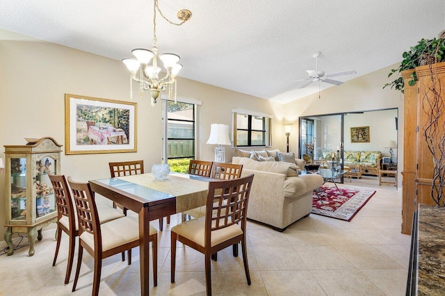 dining space featuring a textured ceiling, ceiling fan with notable chandelier, light tile patterned floors, and lofted ceiling